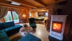 a living room with a fireplace and a table at Osada Kuboski Dom z Bali Leśny Zakątek in Kamesznica