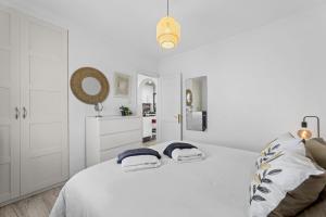 a white bedroom with a large bed with two towels at Jardin del sol 17 in Playa Blanca +10 photos