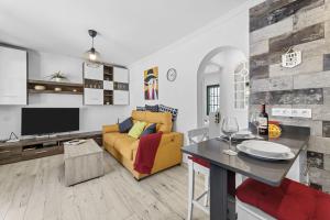 uma sala de estar com um sofá amarelo e uma mesa em Jardin del sol 17 em Playa Blanca