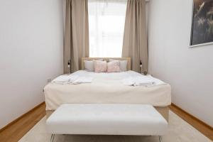 ein Schlafzimmer mit zwei Betten mit weißen Laken und einem Fenster in der Unterkunft OrestaLiving - 2BR On the Danube Canal in Wien