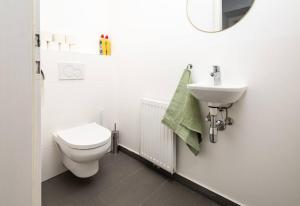 ein weißes Badezimmer mit Toilette und Waschbecken in der Unterkunft OrestaLiving - 2BR On the Danube Canal in Wien