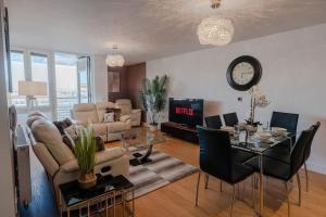 a living room with a table and a clock on the wall at Marina with a view / 2 bd flat in Brighton & Hove