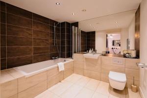 ein Badezimmer mit einer Badewanne, einem WC und einem Waschbecken in der Unterkunft Marina with a view / 2 bd flat in Brighton & Hove