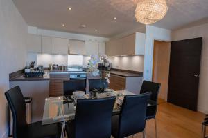 een eetkamer en een keuken met een glazen tafel en stoelen bij Marina with a view / 2 bd flat in Brighton & Hove