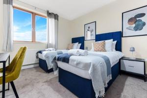 a bedroom with two beds and a desk and a window at City Penthouse with Scenic View Balcony in Milton Keynes