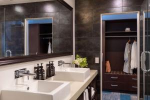 a bathroom with two sinks and a mirror at Rydges Auckland in Auckland