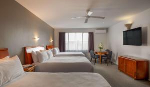 um quarto de hotel com duas camas e uma televisão em Arawa Park Hotel, Independent Collection by EVT em Rotorua