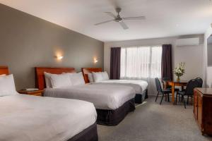 a hotel room with two beds and a table at Arawa Park Hotel, Independent Collection by EVT in Rotorua