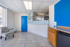 uma grande cozinha com uma porta azul e uma cadeira em Rodeway Inn em Union