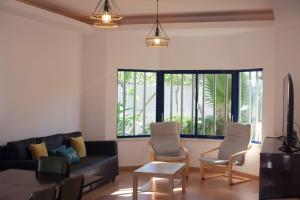 - un salon avec un canapé noir et des chaises dans l'établissement FLH Caparica Town House with Pool, à Costa da Caparica