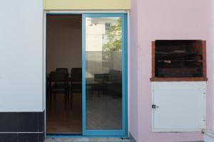 une porte vitrée donnant sur une pièce avec une table dans l'établissement FLH Caparica Town House with Pool, à Costa da Caparica 31 autres photos