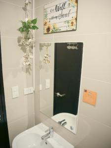 a bathroom with a mirror and a sink and a toilet at The Bat Cave 2 @Manhattan Heights in Manila