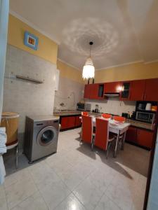 eine Küche mit einem Tisch und einer Waschmaschine in der Unterkunft Immeuble walili in Fès