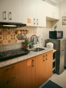 a kitchen with a sink and a stove at The Bat Cave 2 @Manhattan Heights in Manila