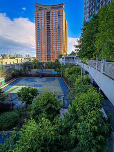 a tennis court in front of a tall building at The Bat Cave 2 @Manhattan Heights in Manila