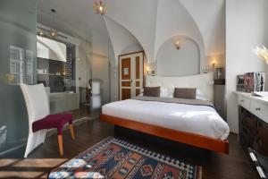 a bedroom with a king sized bed and a bathroom at Design Hotel Neruda in Prague