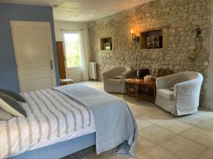 a bedroom with a bed and a table and chairs at Domaine Bleu Celeste in Couleuvre