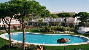 una grande piscina di fronte a un grande edificio di NPG429 - Holiday Beach House on the Golf Course a Huelva