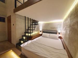 ein Schlafzimmer mit einem weißen Bett und einer Treppe in der Unterkunft New Golden Clouds - Non Smoking Homestay in Garut