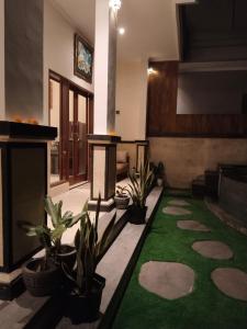 a living room with a fireplace and a green carpet at DANU HOUSE UBUD in Ubud