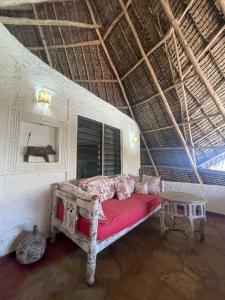 ein Schlafzimmer mit einem Bett und einem Tisch in einem Zimmer in der Unterkunft Kaleb's Beachfront Villa in Malindi