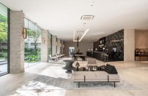 a lobby with couches and chairs in a building at Maison Hotel Bangkok in Bangkok