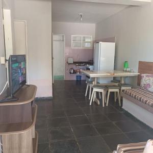 uma cozinha com uma mesa e um frigorífico em Residencial Bahia Sol em Nova Viçosa
