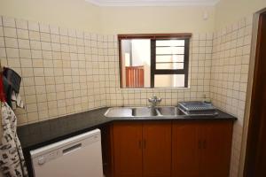 uma pequena cozinha com um lavatório e um espelho em Ocean Dream Self-Catering em Swakopmund