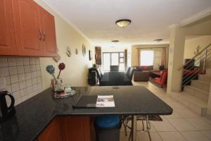 a kitchen with a counter top and a living room at Ocean Dream Self-Catering in Swakopmund