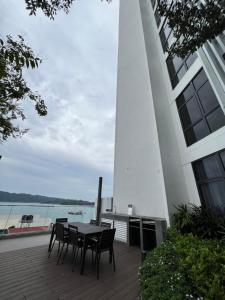 a table and chairs in front of a building with a lighthouse at NOSTRE HOMESTAY THE SHORE KK in Kota Kinabalu
