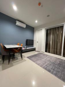 a room with a table and chairs and a tv at NOSTRE HOMESTAY THE SHORE KK in Kota Kinabalu