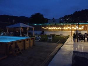 a swimming pool at night with lights on a building at Villa Franz House Casa de Invitados in Canyelles