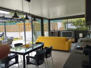 a living room with a yellow couch and a table at Villa Franz House chic in Canyelles