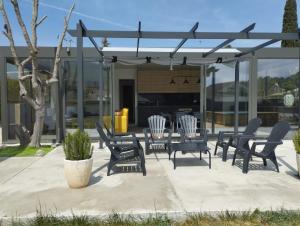 a patio with chairs and a table and a piano at Villa Franz House Casa de Invitados in Canyelles