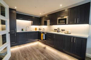 uma cozinha com armários pretos e bancadas brancas em Stunning 1 bed flat in the heart of Brighton lanes em Brighton & Hove