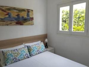 a bedroom with a white bed with a window at Villa Franz House Casa de Invitados in Canyelles