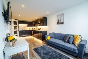 a living room with a blue couch and a kitchen at Stunning 1 bed flat in the heart of Brighton lanes in Brighton & Hove