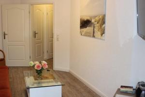 un soggiorno con un vaso di fiori su un tavolo di vetro di Residenz Ostseestrand Nr_ 11 a Scharbeutz