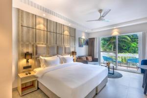 a bedroom with a large bed and a large window at Ramada by Wyndham Goa Arpora in Arpora