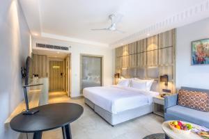 a hotel room with a bed and a couch at Ramada by Wyndham Goa Arpora in Arpora