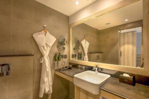 a bathroom with a sink and a mirror at Ramada by Wyndham Goa Arpora in Arpora