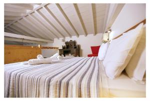 um quarto com uma cama grande com duas toalhas em Daphne superior castle suite em Monemvasia