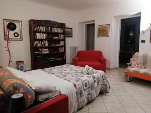 - un salon avec un lit et une chaise rouge dans l'établissement Nicoletta House, à Moncalieri