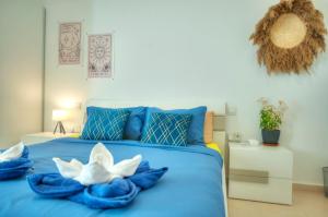 um quarto com uma cama azul com flores brancas em Modern 1BR Stylish Maisonette with Yard - Bugibba Promenade em St. Paul's Bay