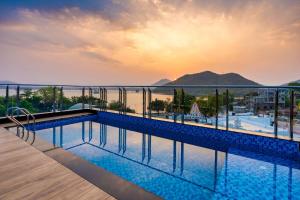 einen Pool in einem Gebäude mit Meerblick in der Unterkunft The Grand Fateh in Udaipur