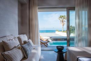 a living room with a couch and a view of the ocean at Niriides Palace in Gournes