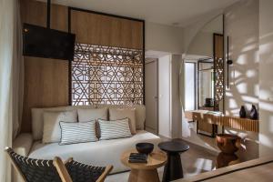 a bedroom with a bed with a chair and a table at Niriides Palace in Gournes +41 photos