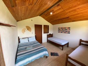 a bedroom with a bed and a bench in it at Pousada Nikimba in São Roque de Minas