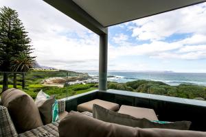 a balcony with a couch and a view of the ocean at Bayview 203 in Hermanus