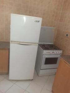 a white refrigerator and an oven in a kitchen at Sheraton ap . in Hurghada